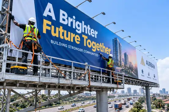 Installers fitting a highway billboard banner